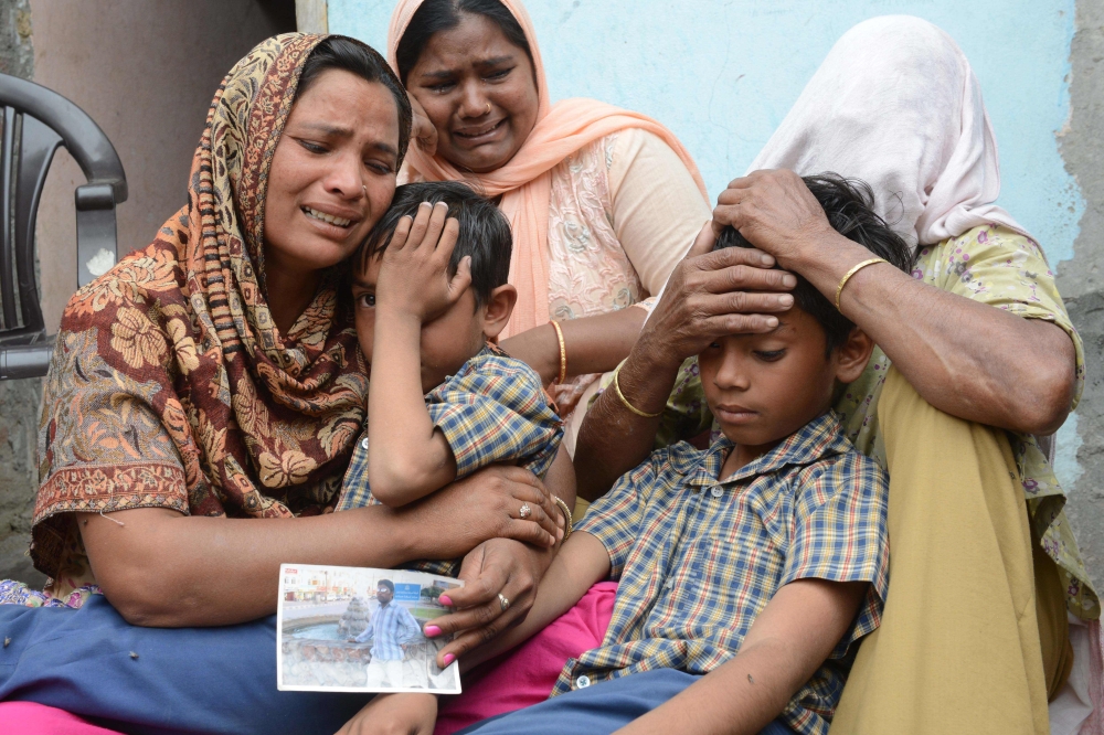 Indian resident Seema (L), her sons Karan (2R) and Arjun (2L) and her mother in-law Jeeto (R) react following confirmation by External Affairs minister Sushma Swaraj that her husband Sonu had been killed in Iraq in the village of Chawinda Devi some 22 kms