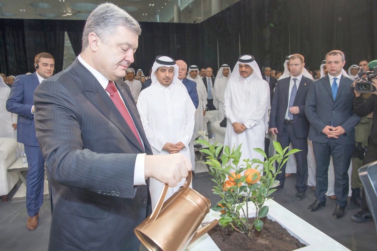 Prime Minister and Interior Minister, H E Sheikh Abdullah bin Nasser bin Khalifa Al Thani, watching as Ukraine President Petro Poroshenko watering a plant during the opening of the 6th Qatar International Agricultural Exhibition & Conference.