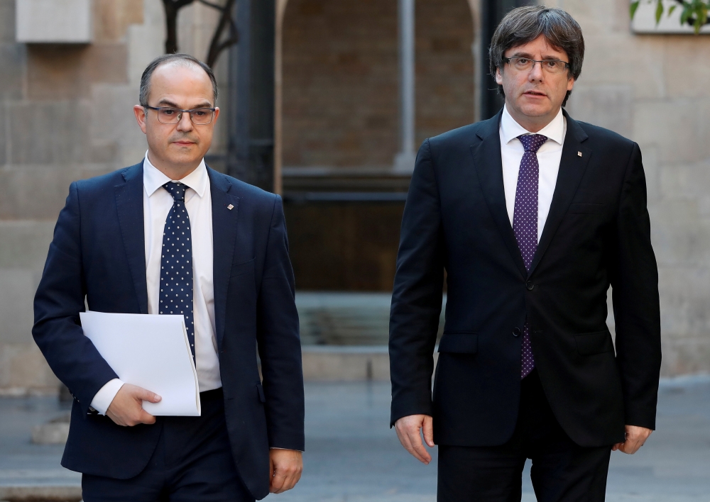 Catalan President Carles Puigdemont (R) walks with Catalan Government Presidency Councillor Jordi Turull as they arrive to hold a cabinet meeting at the regional government headquarters, the Generalitat, in Barcelona, Spain October 17, 2017. REUTERS/Gonza