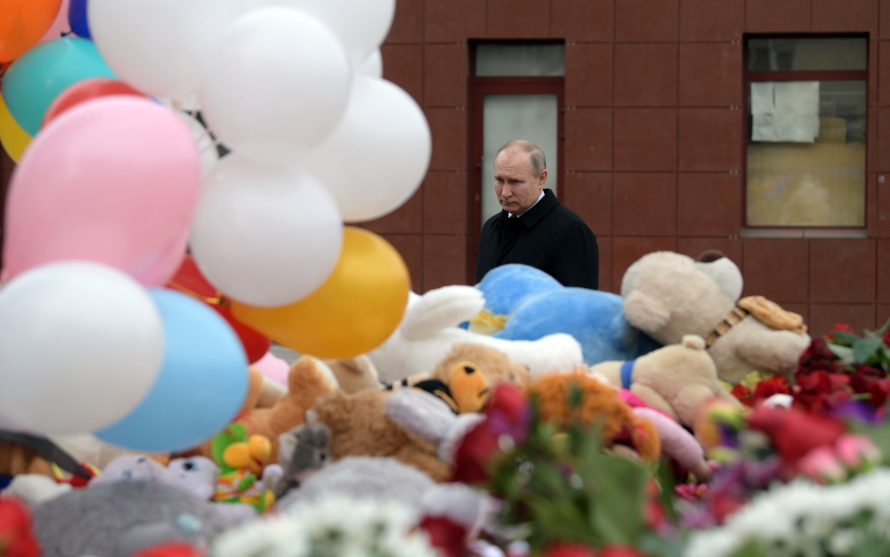 Russian President Vladimir Putin lays flowers in tribute to the victims of a fire at a shopping centre in Kemerovo on March 27, 2018.  / AFP / SPUTNIK / Alexey DRUZHININ 