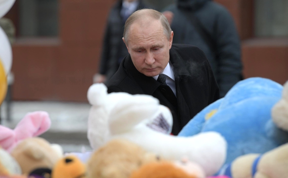 Russian President Vladimir Putin lays a flower at the shopping mall in Kemerovo where over 64 people were killed on March 25, in Kemerovo, Russia on March 27, 2018. Anadolu
