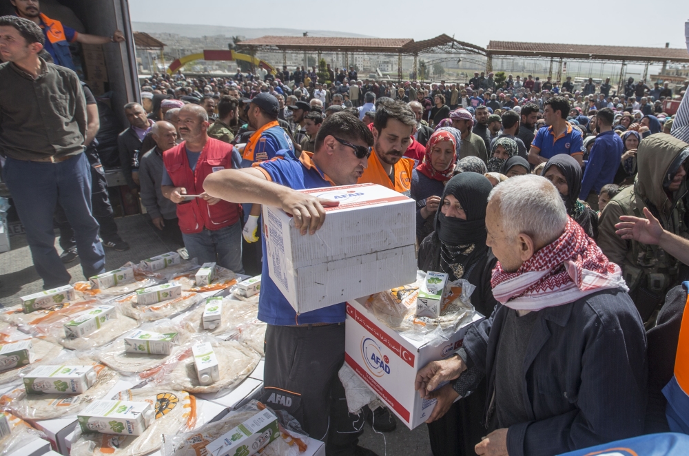 A member of Turkey's Disaster Management Agency (AFAD) distributes food and hygiene packages to Syrian families in Afrin, Syria after Turkish Armed Forces and Free Syrian Army (FSA) took complete control of northwestern Syria's Afrin within the 