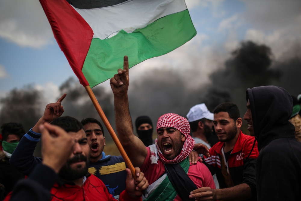 Demonstrators shout slogans and hold Palestinian flags during the demonstration under the name of the 