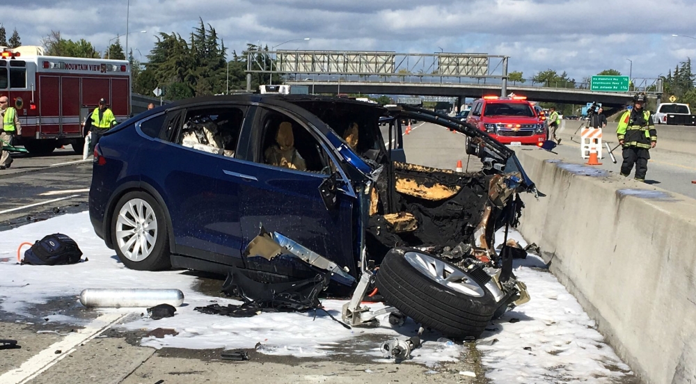 Rescue workers attend the scene where a Tesla electric SUV crashed into a barrier on U.S. Highway 101 in Mountain View, California, March 25, 2018. 