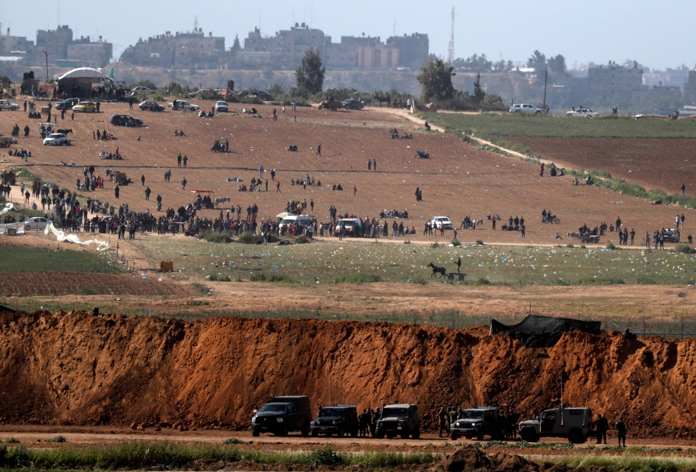 A picture taken on March 31, 2018, near the Israeli border with Gaza, shows Palestinian demonstrators gathering for a protest a day after clashes with Israeli forces on Land Day.  AFP / Ahmad Gharabli