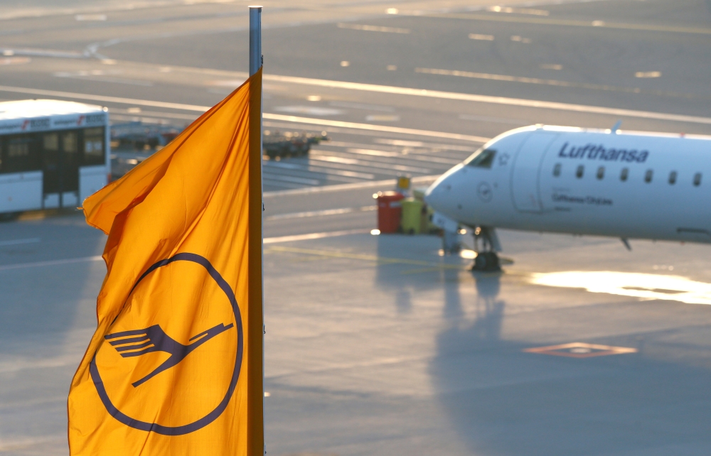 FILE PHOTO: A plane by Lufthansa is seen next to a Lufthansa flag at the international airport in Munich, Germany, January 9, 2018. REUTERS/Michaela Rehle
