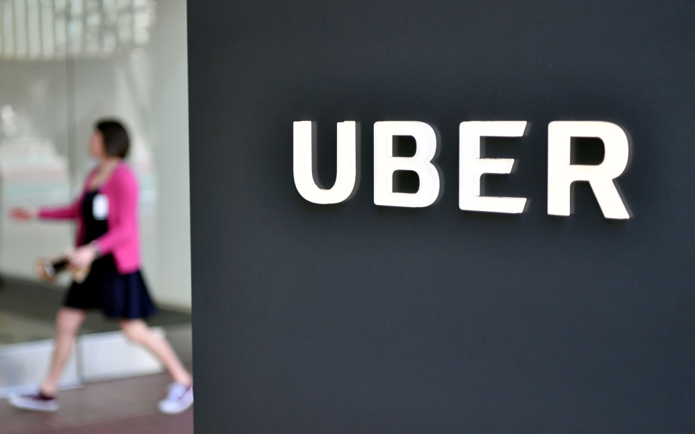 (FILES) In this file photo taken on February 5, 2018, a woman walks into the Uber Corporate Headquarters building in San Francisco, California. AFP / JOSH EDELSON