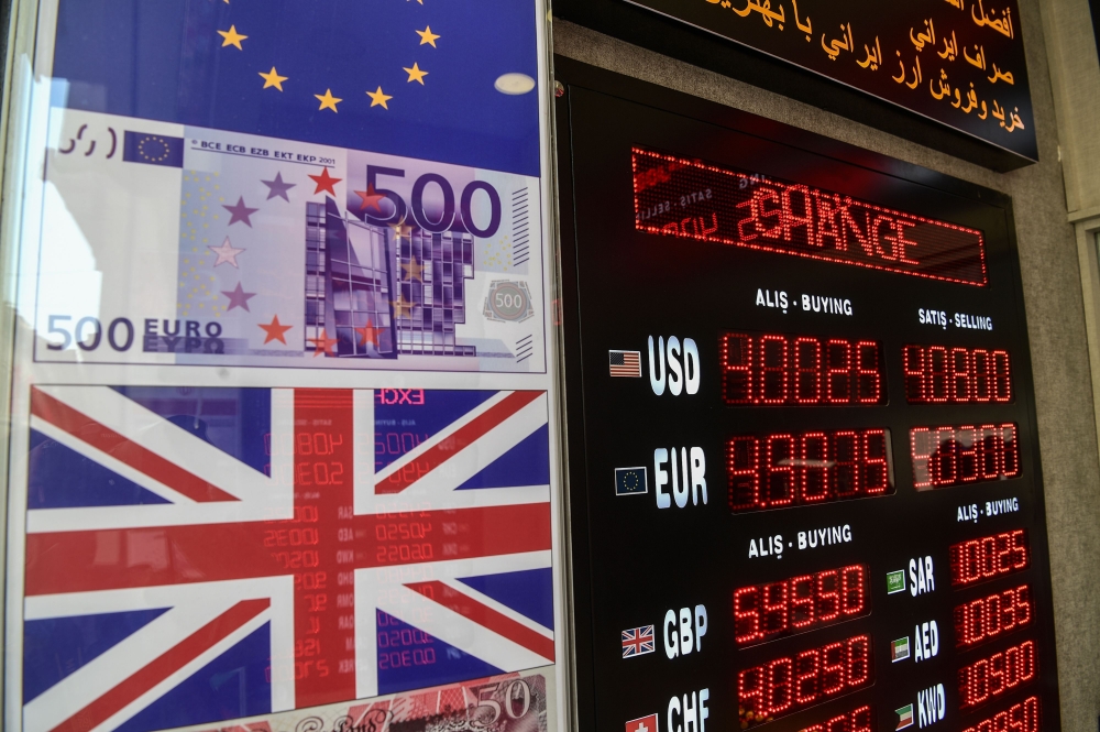 This picture is taken on April 10, 2018 in Istanbul shows a display of foreign exchange rates against Turkish liras at Istiklal avenue. / AFP / OZAN KOSE
