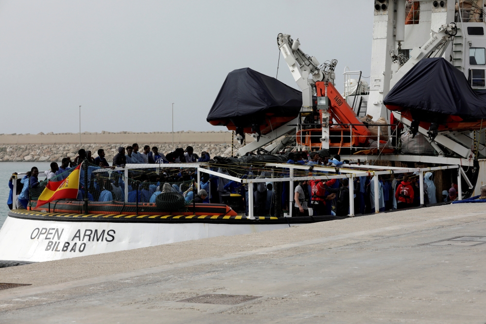 (FILE PHOTO) Migrants wait to disembark from Spanish NGO Proactiva Open Arms in the Sicilian harbour of Pozzallo, Italy, March 17, 2018. REUTERS/Antonio Parrinello
