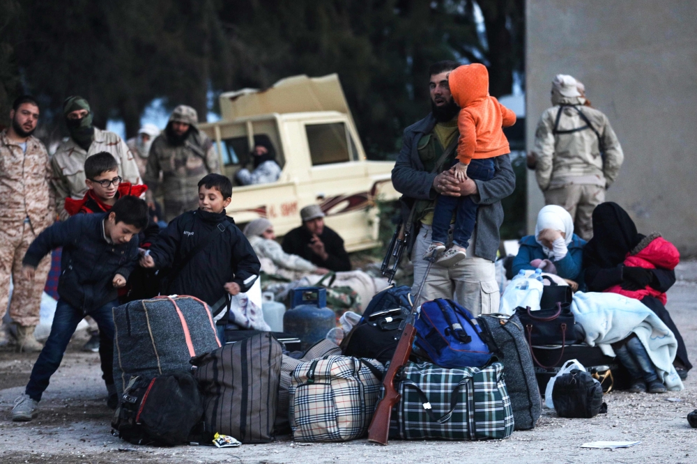 A convoy carrying opposition fighters and their families from the East Qalamun area, 60 kilometres (35 miles) northeast of Syria's capital, arrives in Qalaat al-Madiq, some 45 kilometres northwest of the central city of Hama, on April 23, 2018, after they
