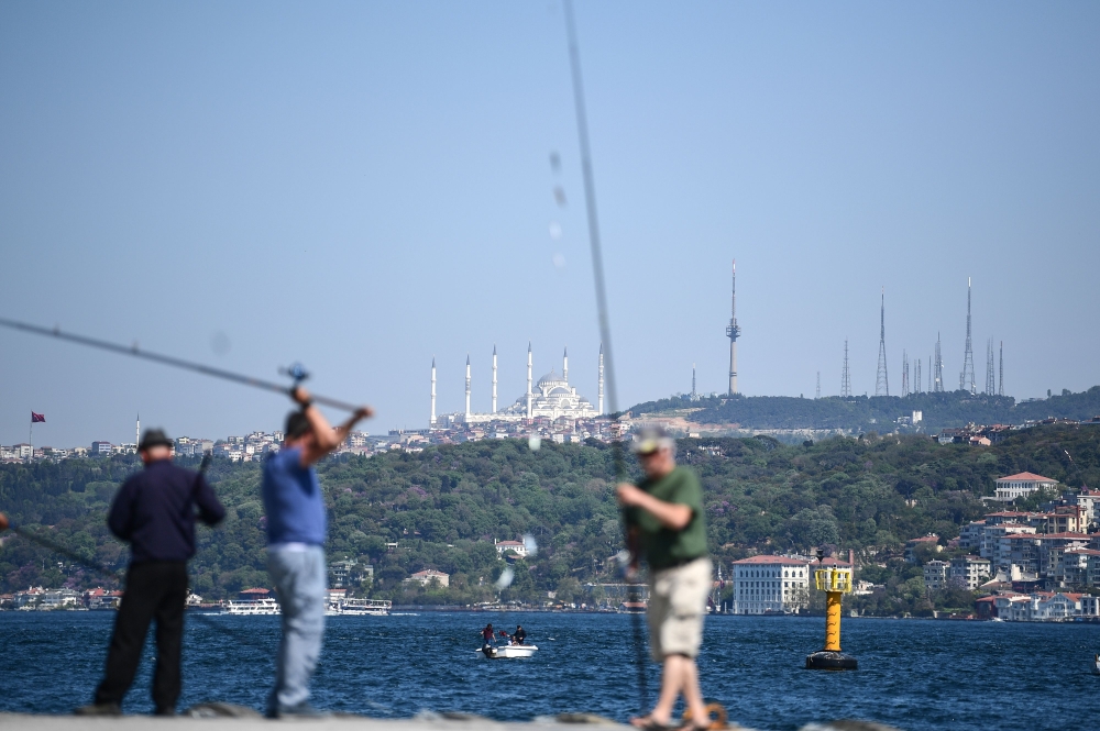 People are fishing on bosphorus river as new built Camlica mosque is seen in the backround on April 26, 2018 in Istanbul. AFP / OZAN KOSE

