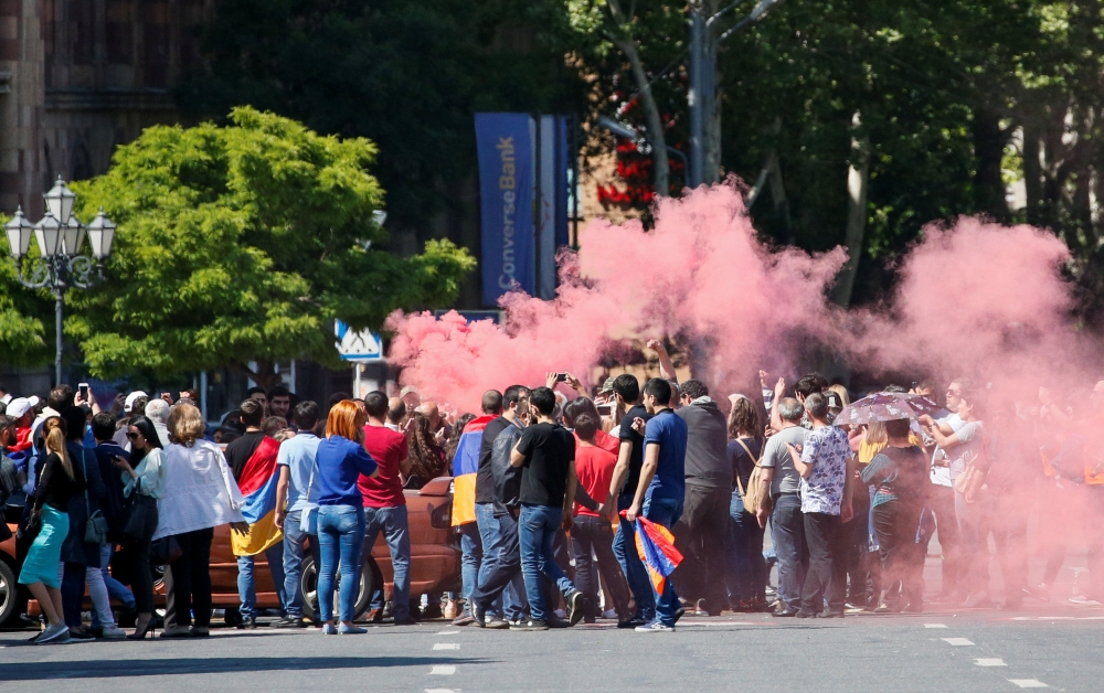 Armenian opposition supporters light a flare as they block a road, after protest movement leader Nikol Pashinyan announced a nationwide campaign of civil disobedience in Yerevan, Armenia. REUTERS/Gleb Garanich