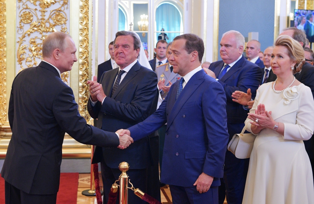 Russian Prime Minister Dmitry Medvedev (3rd L) and German former Chancellor Gerhard Schroeder (2nd L) greet Vladimir Putin (L), who is sworn as Russian President during an inauguration ceremony at the Kremlin in Moscow, Russia May 7, 2018. Alexei Druzhini