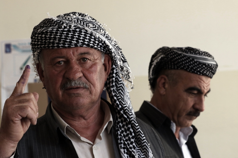 A member of the Kurdish Iraqi security shows his ink-stained index finger after voting at a polling station ahead of parliamentary elections in Arbil, the capital of the Kurdish autonomous region in northern Iraq on May 10, 2018. AFP / SAFIN HAMED