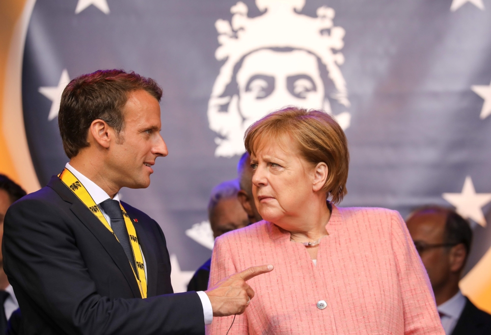 France's President Emmanuel Macron and German Chancellor Angela Merkel confer at the end of the Charlemagne prize award ceremony on May 10, 2018 in Aachen, western Germany.   AFP / LUDOVIC MARIN
