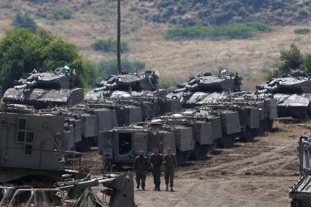 Israeli soldiers walk among armored vehicles in the Israeli-occupied Golan Heights, Israel May 10, 2018. REUTERS/Ronen Zvulun