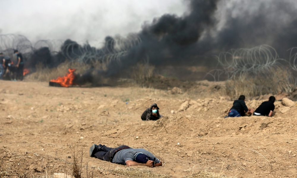 A wounded Palestinian is pictured on the ground during clashes with Israeli forces along the border with the Gaza strip, east of Gaza City, on May 11, 2018, as Palestinians demonstrate for the right to return to their historic homelands in what is now Isr
