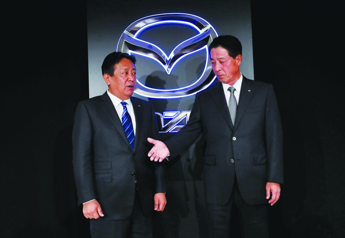 Mazda Motor Corp. outgoing President Masamichi Kogai (R) and next president Akira Marumoto shake hands at a news conference in Tokyo, Japan May 11, 2018. Reuters/Kim Kyung-Hoon