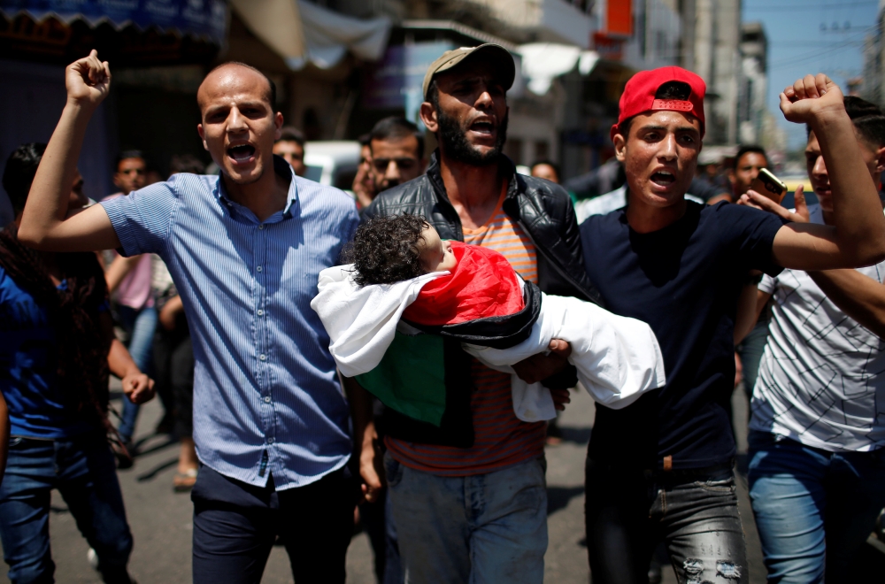 Mourners carry the body of eight-month-old Palestinian infant Laila al-Ghandour, who died after inhaling tear gas during a protest against U.S embassy move to Jerusalem at the Israel-Gaza border, during her funeral in Gaza City May 15, 2018. REUTERS/Moham