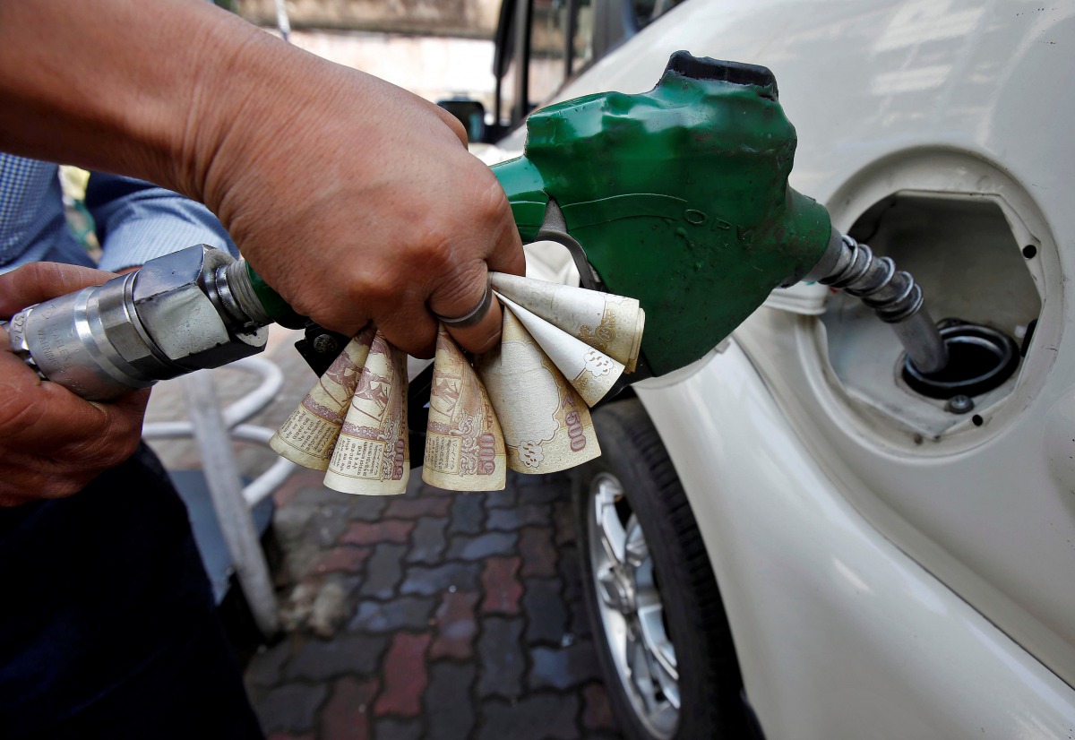A worker fills diesel in a car as he holds 500 Indian rupee banknotes at a fuel station in Kolkata, India, November 9, 2016. (Reuters / Rupak De Chowdhuri) 