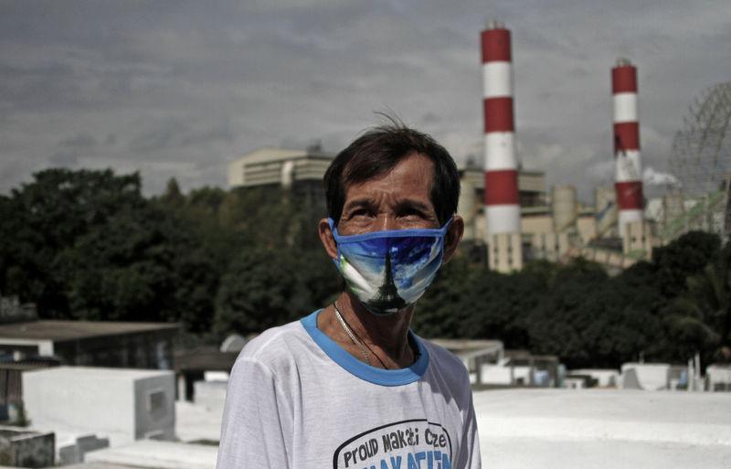 Elpidio dela Cruz, 62, stands in a graveyard adjacent to a 140 megawatt coal-fired power plant in Barangay Lamao in Limay, Bataan, northern Philippines, January 18, 2018. Thomson Reuters Foundation/Alanah Torralba