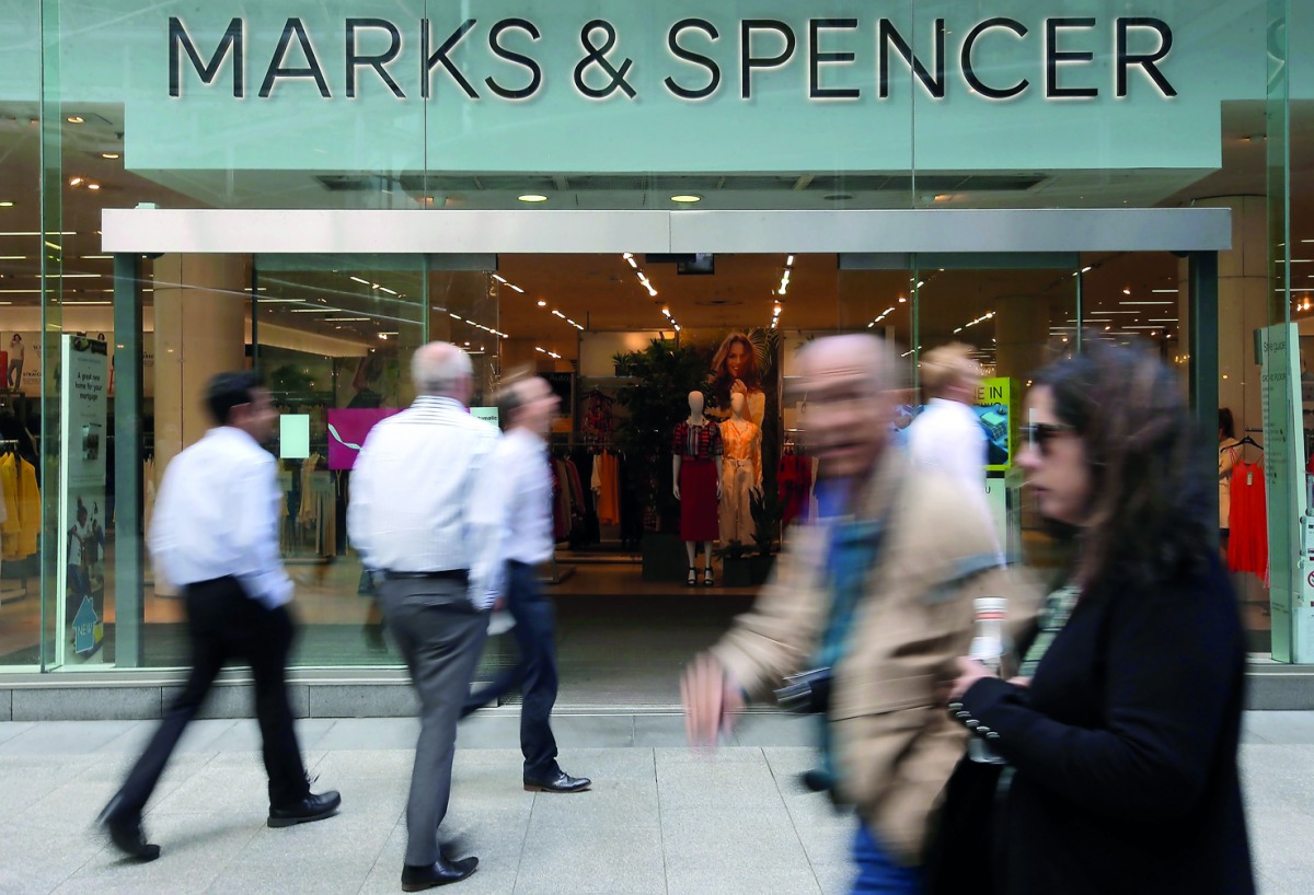 Pedestrians walk past a Marks and Spencer (M&S) shop in central London on May 23, 2018.  AFP / Daniel Leal-Olivas