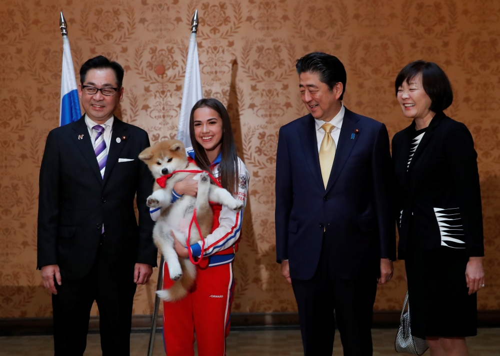 Endo Takashi, head of the Association for the preservation of the purity of the Akito breed, Russian figure skating gold medallist Alina Zagitova, Japanese Prime Minister Shinzo Abe and his wife Akie Abe poses with an Akita Inu puppy presented to Zagitova
