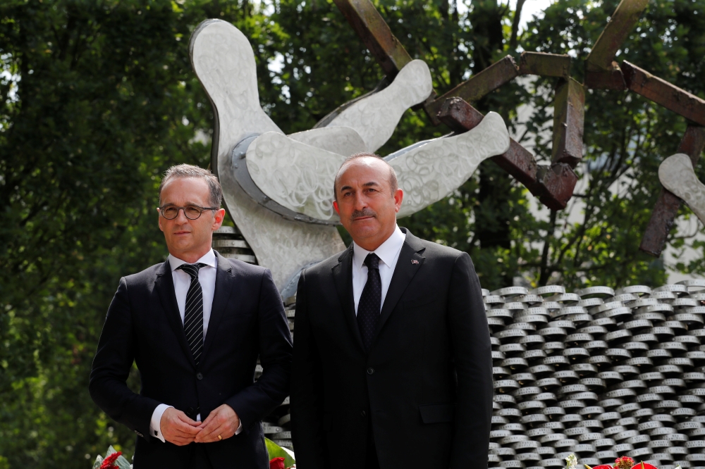 Turkish Foreign Minister Mevlut Cavusoglu and his German counterpart Heiko Maas commemorate the 25th anniversary of an arson attack killing two Turkish women and three girls by right-wing extremists in Solingen, Germany, May 29, 2018. REUTERS/Wolfgang Rat