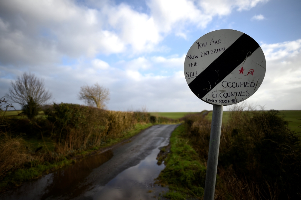 FILE PHOTO: A road which crosses the border from County Donegal in Ireland to County Londonderry in Northern Ireland, is seen from near the border village of Lenamore, Ireland, February 1, 2018. There are no markings apart from the change in roadsigns. RE