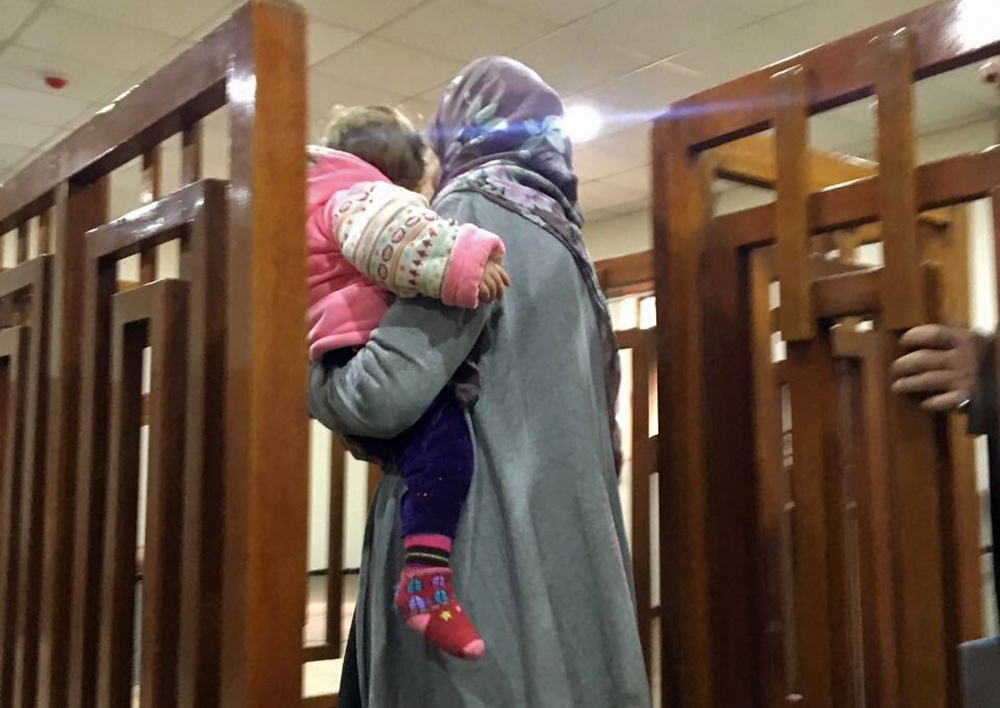 This file photo taken on February 19, 2018, shows Melina Boughedir carriyng her son, arriving in court in the Iraqi capital Baghdad. Melina Boughedir was arrested in former Islamic State group stronghold Mosul with her four children, three of whom have be