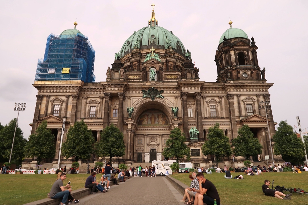 People sit in front of the Berliner Dom after a German policeman shot a man at the Berlin Cathedral, German media reported in Berlin, Germany, June 3, 2018. REUTERS/Fabrizio Bensch