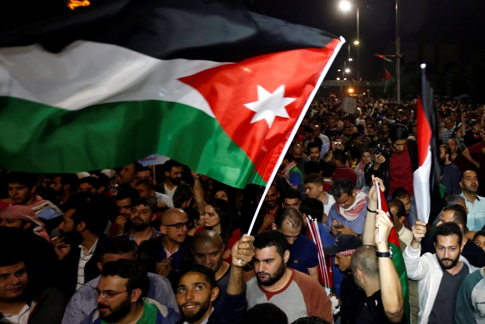 A protester holds up a Jordanian national flag during a protest in Amman, Jordan June 4, 2018. REUTERS/Muhammad Hamed
 