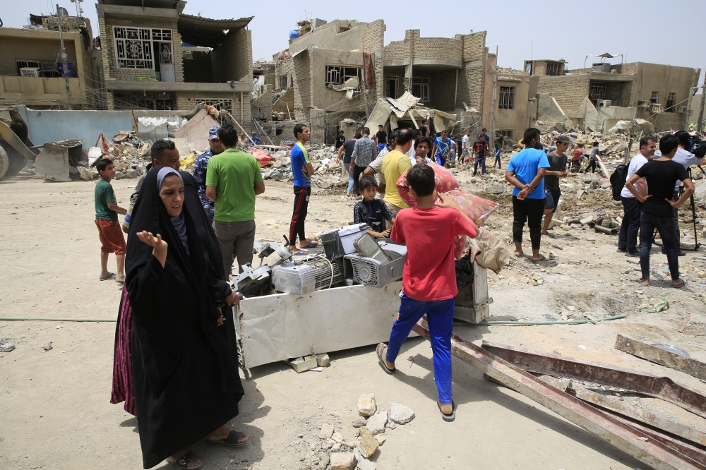 People collect usable belongings after an explosion near a mosque in Baghdad's Sadr City district, Syria on June 07, 2018. Murtadha Sudani - Anadolu
