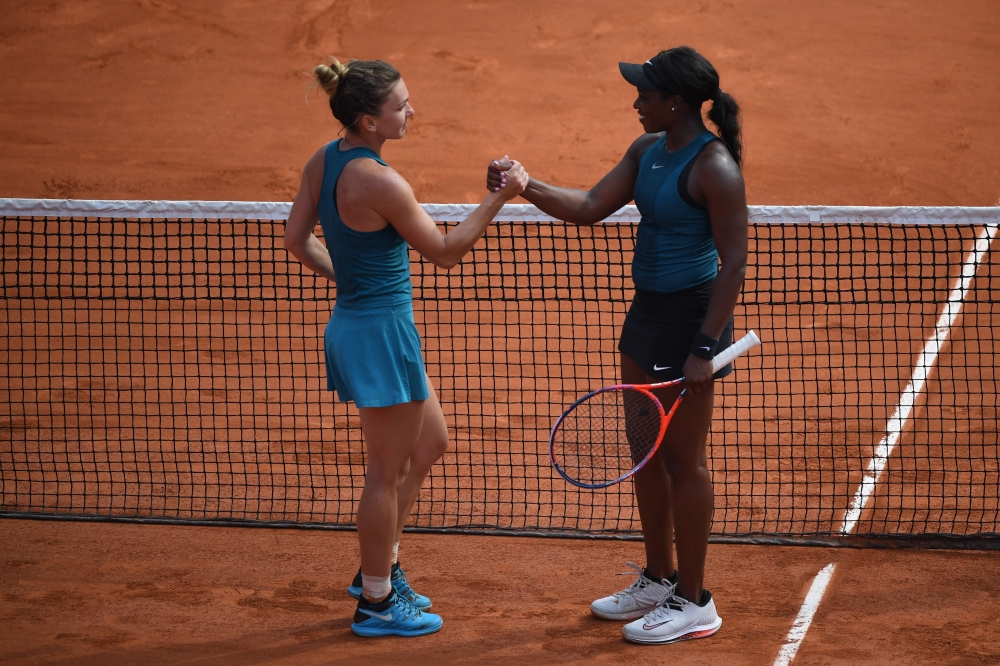 Romania's Simona Halep (L) shakes hands as she celebrates after victory over Sloane Stephens of the US (R) during their women's singles final match on day fourteen of The Roland Garros 2018 French Open tennis tournament in Paris on June 9, 2018. / AFP / E