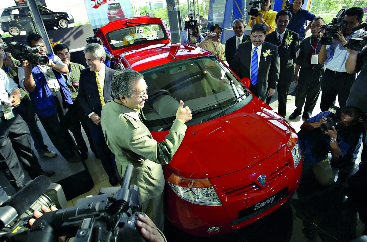 In this file photo taken on June 8, 2005, Mahathir Mohamad gives a thumbs-up sign during the launch of the Proton Savvy, the national carmaker's new model in Kuala Lumpur.  AFP / Tengku Bahar