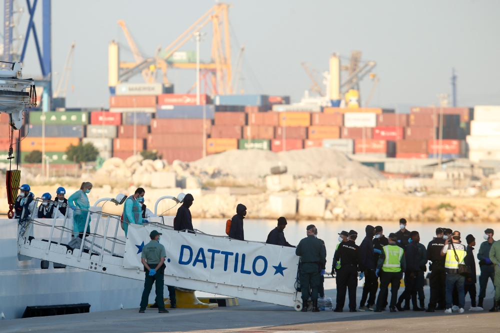 Migrants disembark from the Italian navy boat the Dattilo at the port of Valencia on June 17, 2018. AFP / PAU BARRENA