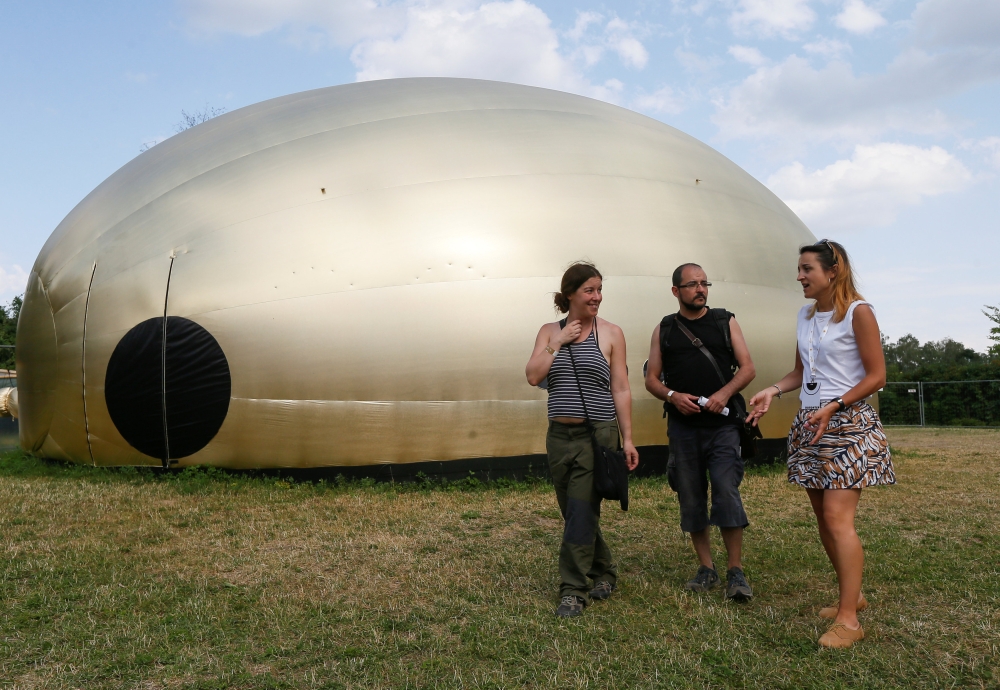 Visitors walk past a giant tent shaped like a gold loaf of bread found in the house of ex-president Viktor Yanukovich after he fled Ukraine in 2014, at the 'Corruption Park' in Kiev, Ukraine June 14, 2018. REUTERS/Valentyn Ogirenko