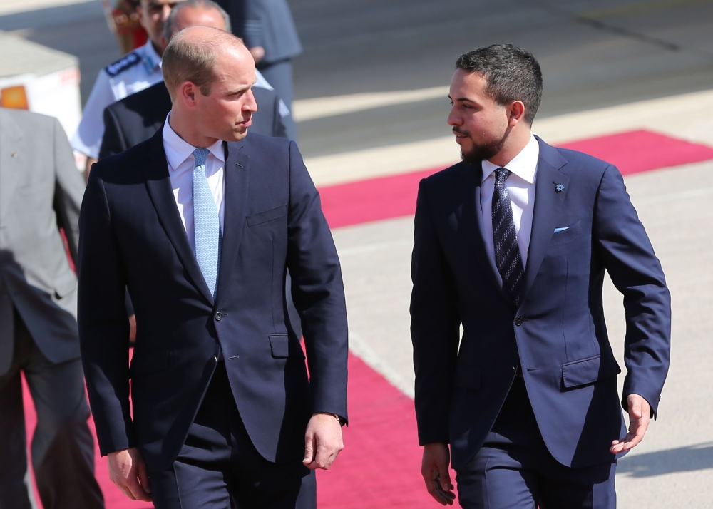 Jordanian Crown Prince Hussein bin Abdullah (R) greets Britain's Prince William, Duke of Cambridge, at Amman's Marka military airport on June 24, 2018. AFP / Khalil Mazraawi 