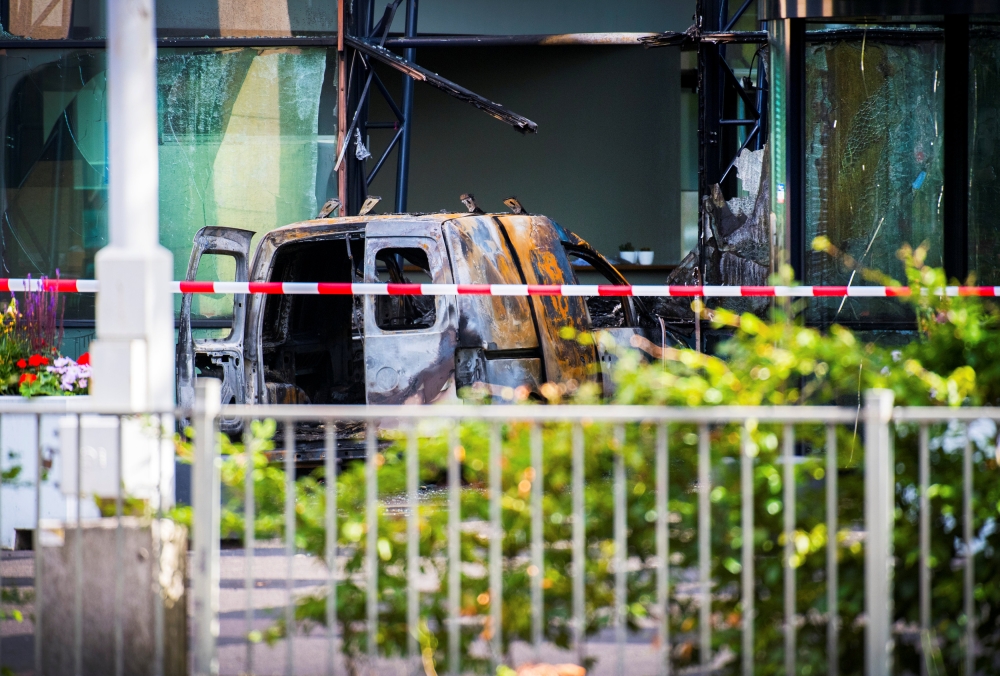 A van is seen burned out after crashing into the glass facade of the head office of Dutch newspaper De Telegraaf in what police said was a deliberate action in Amsterdam, Netherlands June 26, 2018. REUTERS/Piroschka van de Wouw 
