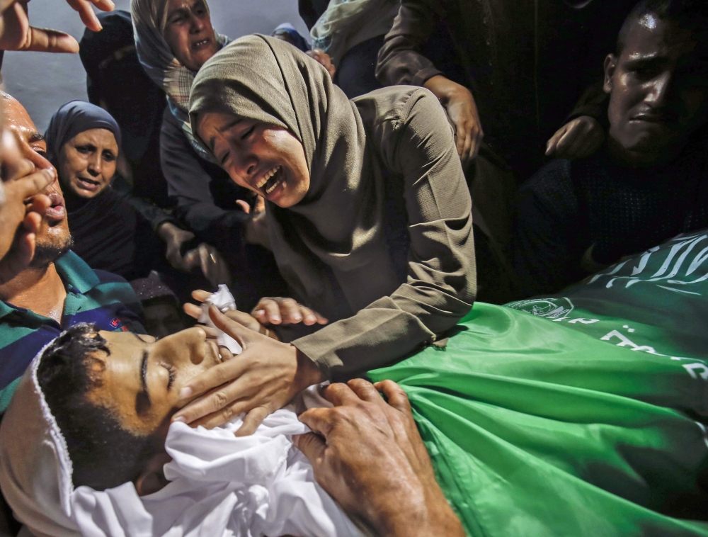 Relatives mourn during the funeral of Abdel Fattah Abu Azoum, 17, a Palestinian teenager who died after being hit by Israeli tank fire on the Gaza border on June 28, 2018, the territory's Hamas-run health ministry said.  AFP / Said Khatib