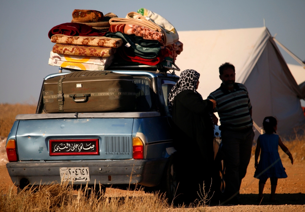 Displaced Syrians from the Daraa province fleeing shelling by pro-government forces wait in a makeshift camp to cross the Jordanian border, near the town of Nasib, southern Syria, on July 1, 2018.  AFP / Mohamad ABAZEED
