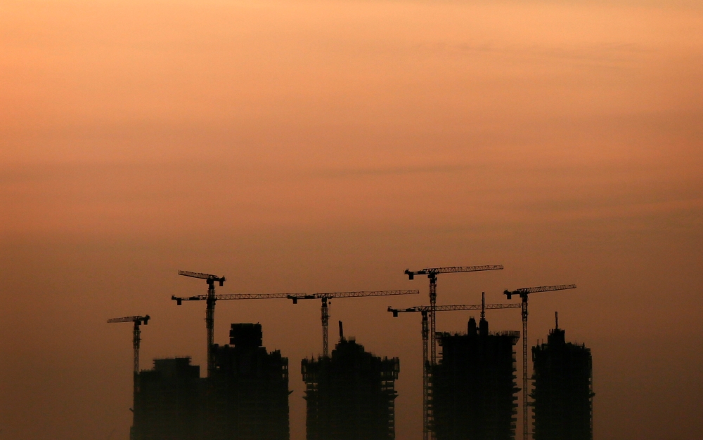 Cranes stand above an apartment complex under construction in Singapore May 15, 2013. Reuters/Tim Wimborne