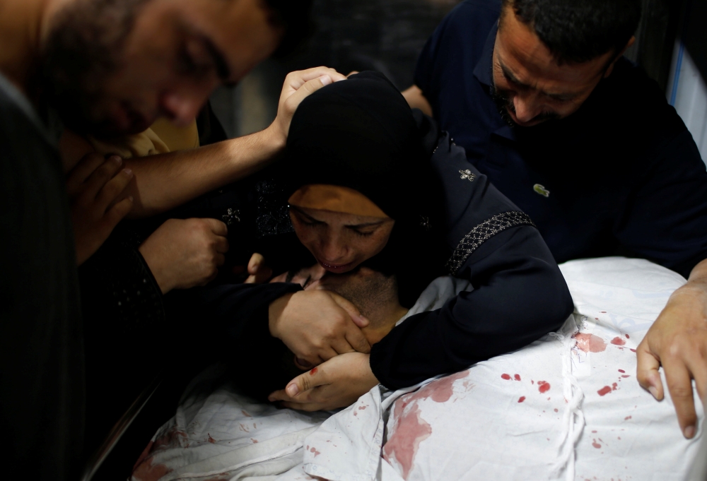 The mother of a Palestinian, who was killed at the Israel-Gaza border during a protest, reacts over his body in Gaza city July 6, 2018. Reuters/Mohammed Salem 
