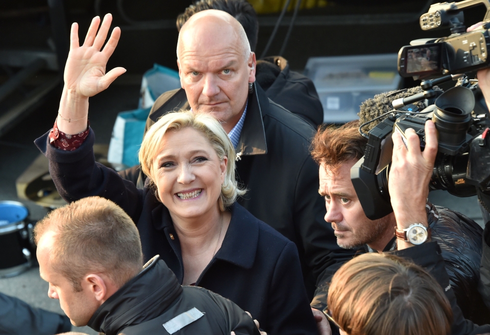 In this file photo taken on May 04, 2017 then French presidential election candidate for the far-right Front National (FN) party, Marine Le Pen (C), followed by her bodyguard Thierry Legier (up), waves before a meeting in Ennemain, northern France. AFP / 
