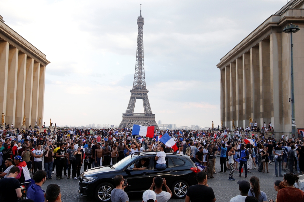 France fans celebrate in front of the Eiffel Tower after France win the World Cup. Reuters/Jean-Paul Pelissier