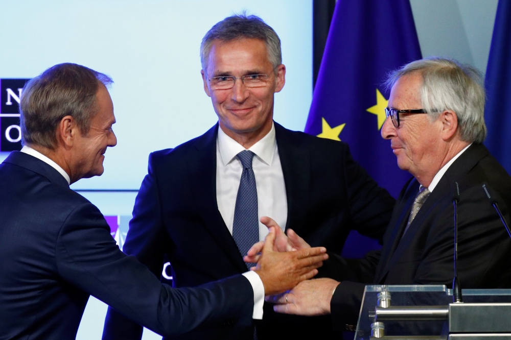 European Council President Donald Tusk greets European Commission President Jean-Claude Juncker next to NATO Secretary General Jens Stoltenberg after signing a new joint declaration on EU-NATO cooperation in Brussels, Belgium July 10, 2018. Reuters/Franco