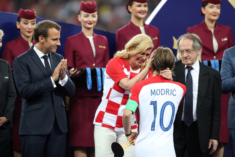 Croatia President Kolinda Grabar-Kitarovic speaks with Croatia's Luka Modric while President of France Emmanuel Macron looks on during the presentation REUTERS/Carl Recine 
