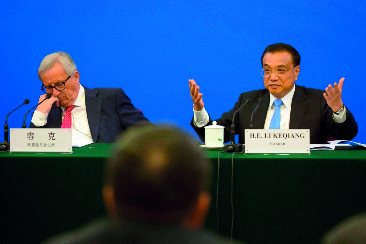 China's Premier Li Keqiang (R) gestures as he calls for action to problems raised by European businessmen, as European Commission President Jean-Claude Juncker (L) looks on, during the China-EU Business Roundtable at the Great Hall of the People in Beijin