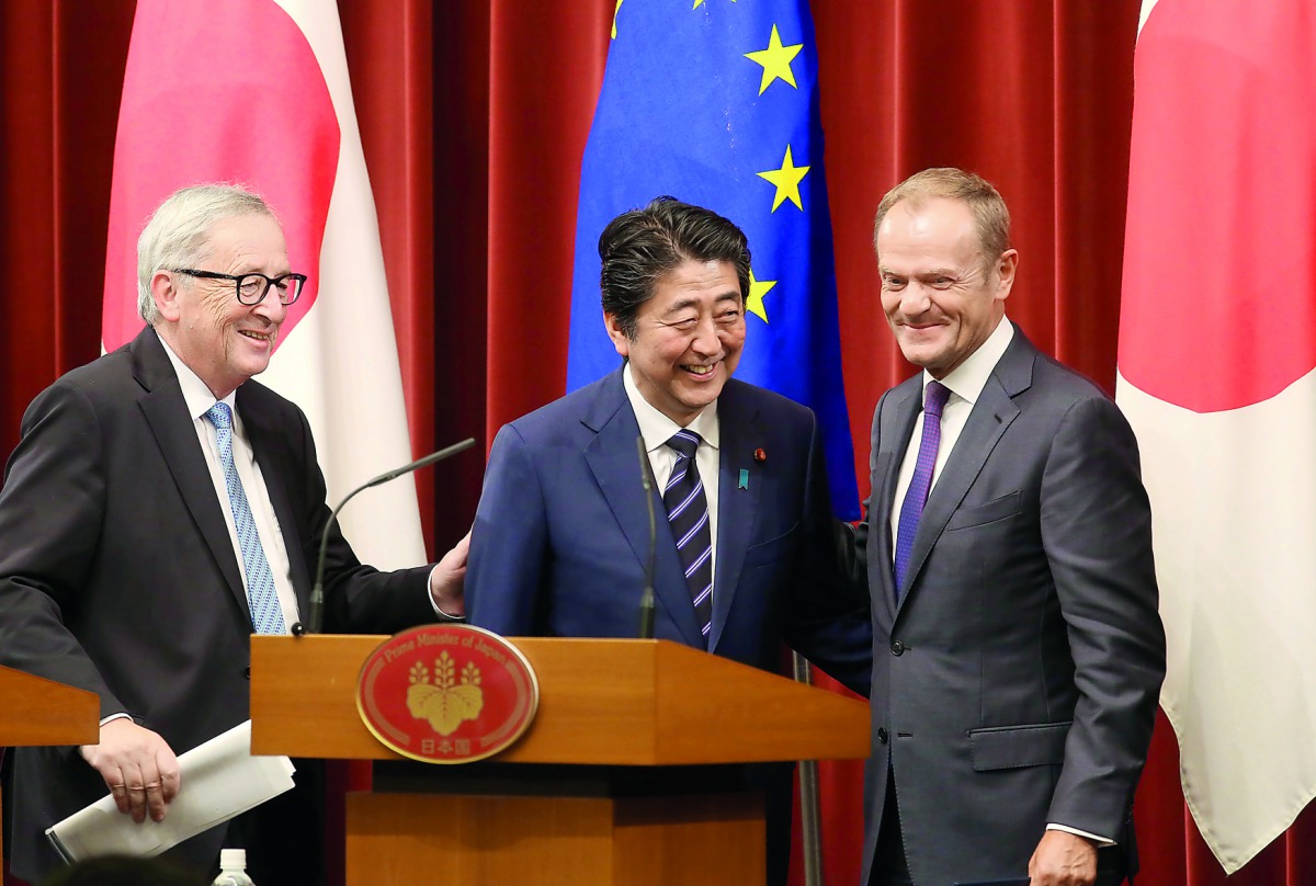 Japanese Prime Minister Shinzo Abe, center, European Commission President Jean-Claude Juncker, left, and European Council President Donald Tusk, right, smile after their joint press conference of Japan-EU summit at Abe's official residence in Tokyo, Tuesd