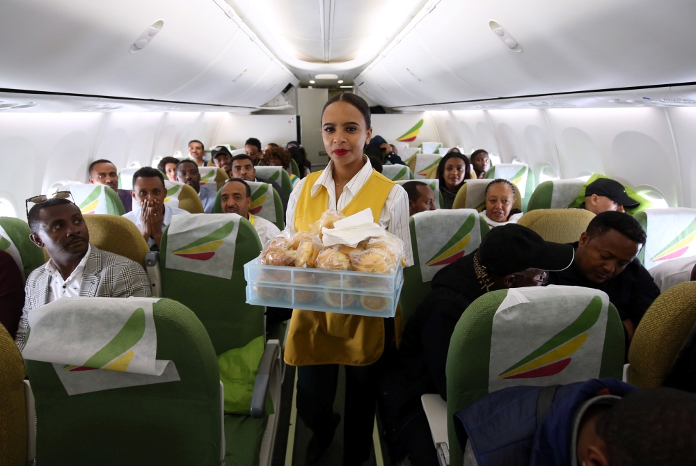 Flight attendant serves passengers with breakfast inside an Ethiopian Airlines ET314 flight to Eritrea's capital Asmara, from the Bole International Airport in Addis Ababa, Ethiopia July 18, 2018. (REUTERS/Tiksa Negeri)